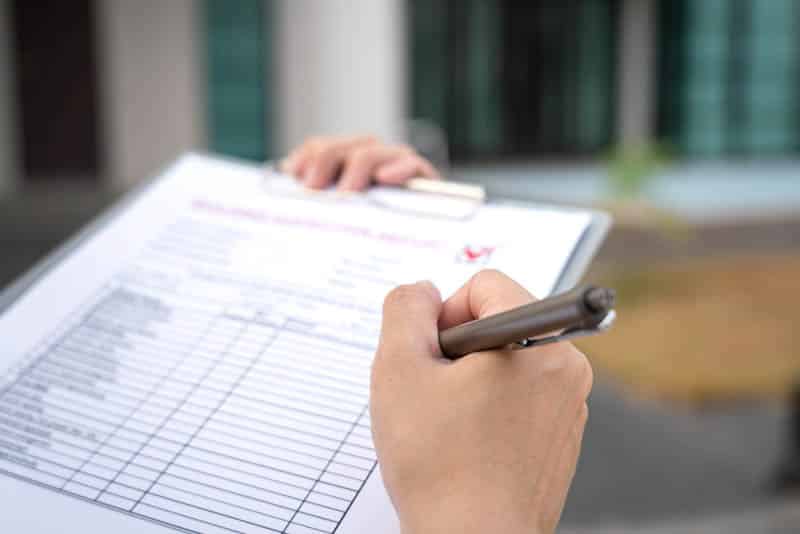 Foreman's hand is using a pen checking on a checklist